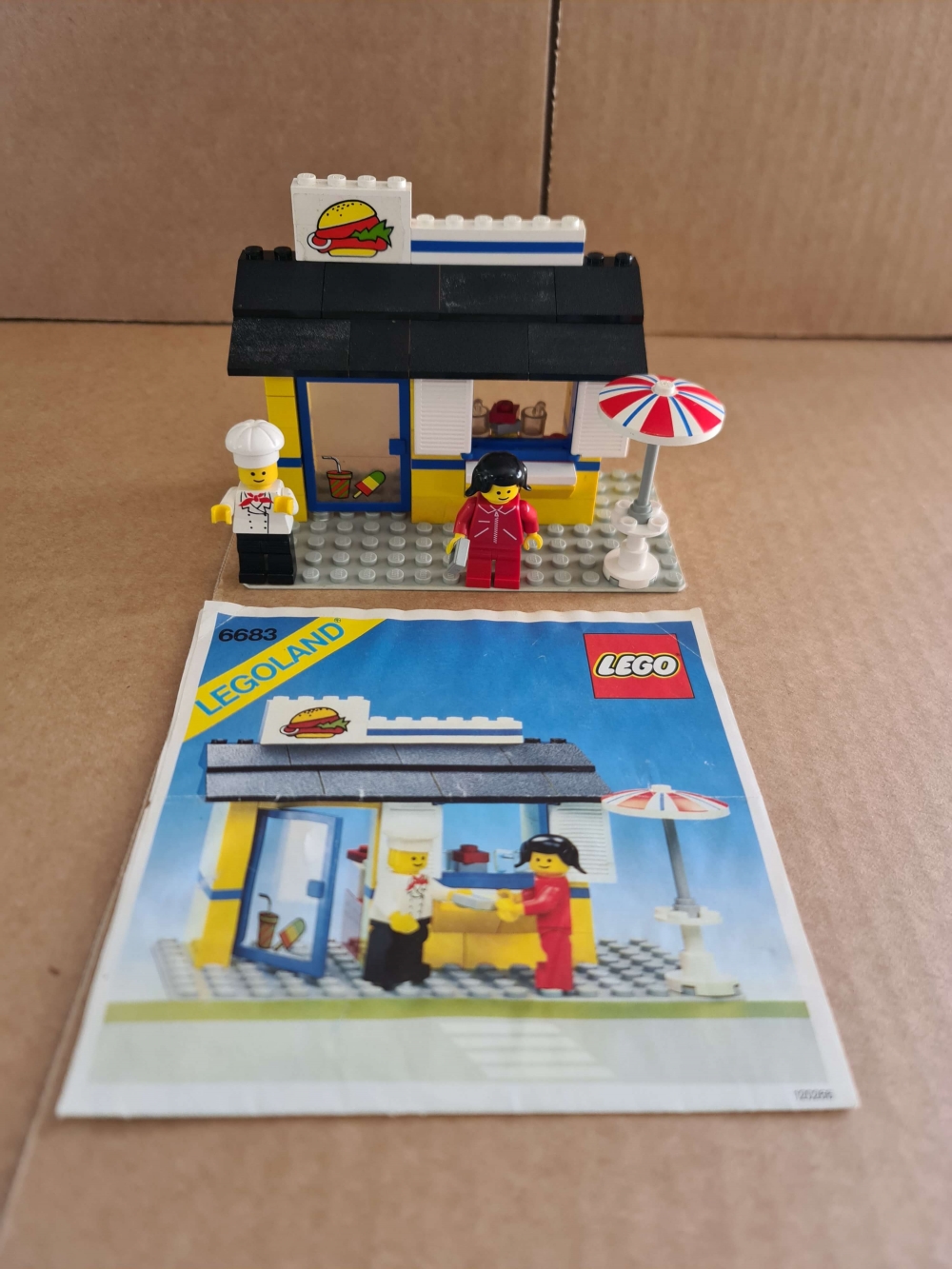 Sett 6683 fra Lego Classic Town serien

Fint komplett sett med manual. Alle klistremerker på. Ikke helt perfekt burgermerke.
Noe støv/møkk på taket.
